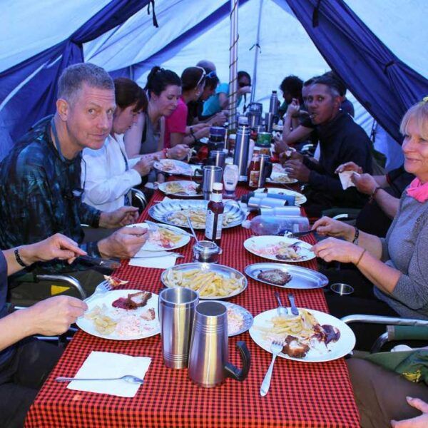 people gathered around a table of meals on kilimanjaro treks